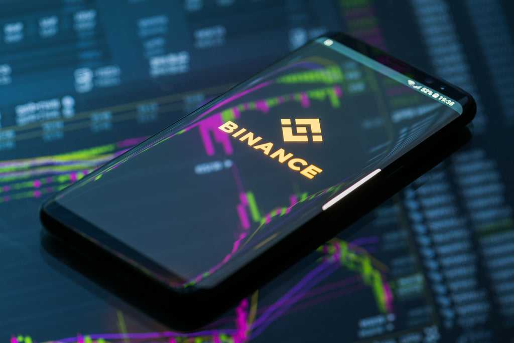 [US] Four-month prison term for Binance founder Changpeng Zhao - Binance logo on phone screen and digital background, Binance boss sentenced to four months, prison for Changpeng Zhao
