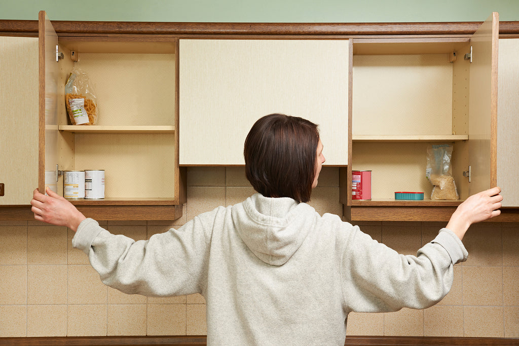 [UK] Half of London’s lowest-paid workers have had to rely on foodbanks - woman looks into empty food cupboards, food bank reliance for low-paid Londoners